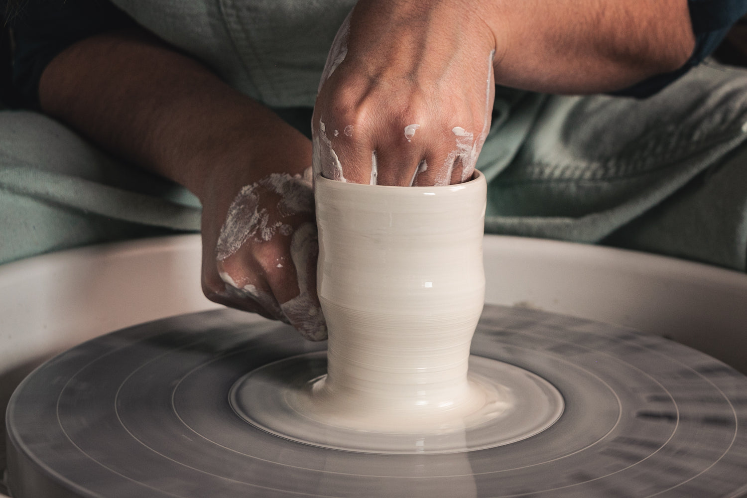 Le geste de l'artisan, délicatesse de la porcelaine qui glisse entre les doigts et se transforme en vase précieux.